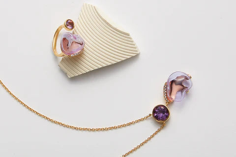 Elegant Aromatopia fragrance jewelry set including a necklace and ring with intricate design details